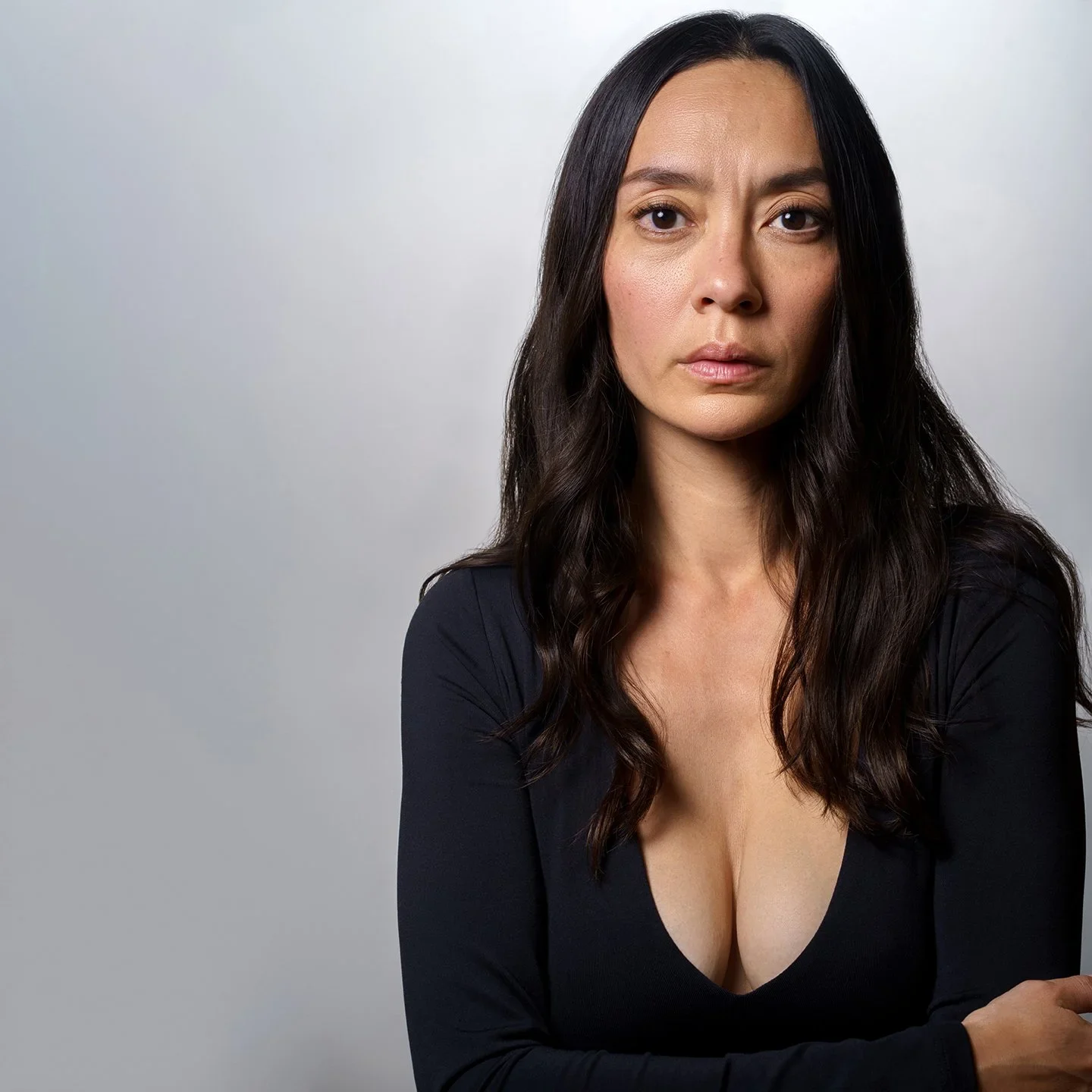 Lucia Micarelli seated against a gray background