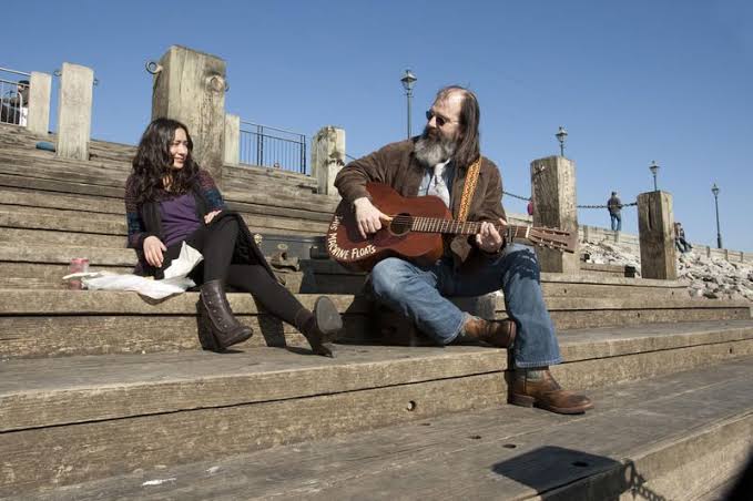 Annie and Wyatt sitting together on the New Orleans riverfront in Treme